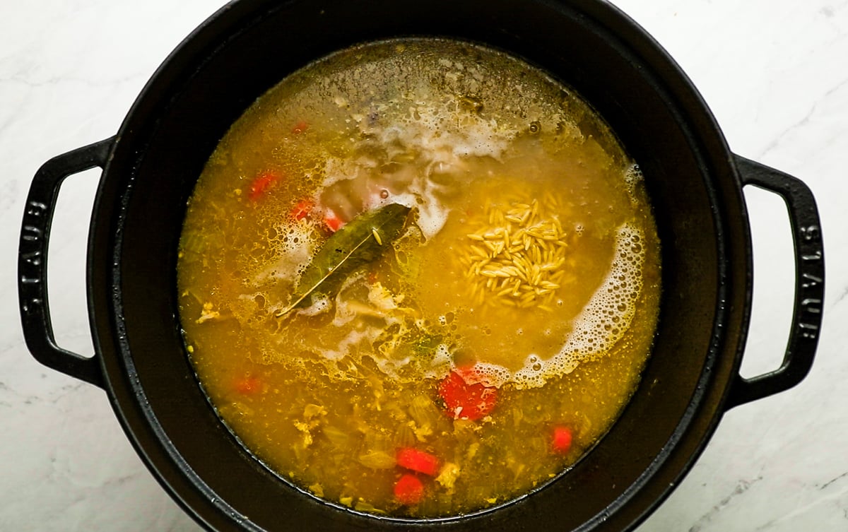 orzo added to chicken soup in pot