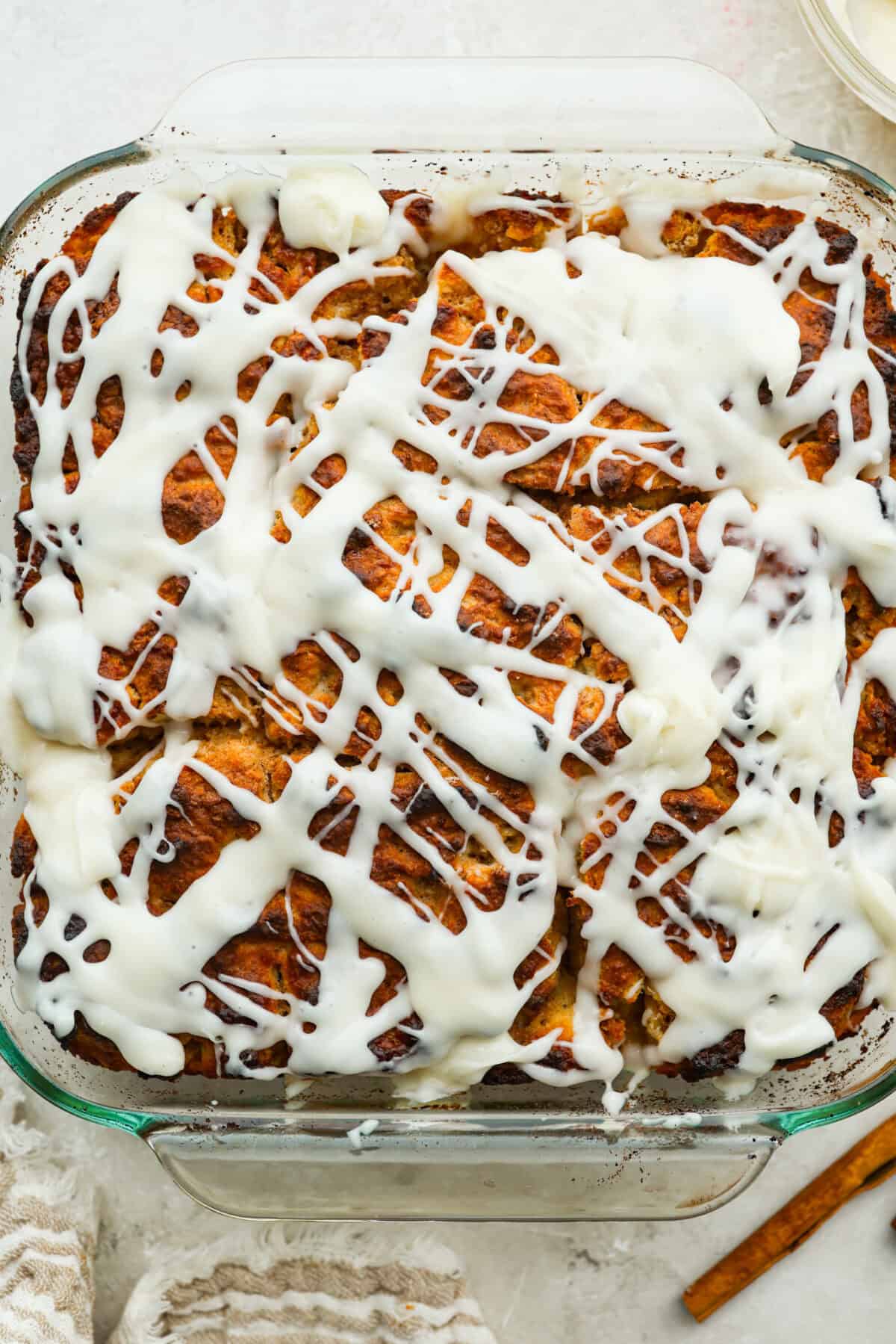 Pan of cinnamon roll butter swim biscuits baked, iced and ready to eat. 