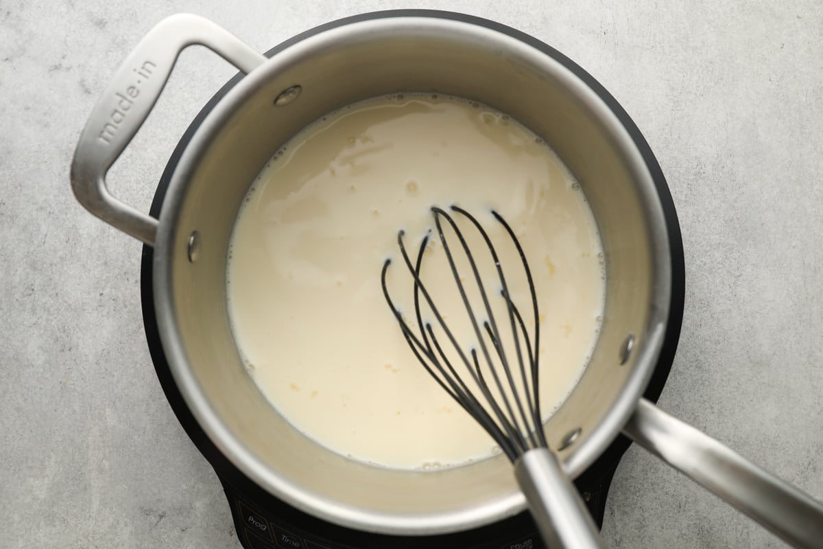 medium saucepan with milk and egg yolk mixture added to sugar, cornstarch and salt