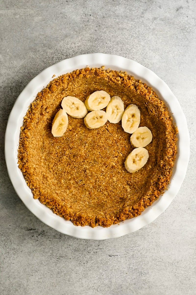 layer of sliced bananas arranged over bottom of pie crust