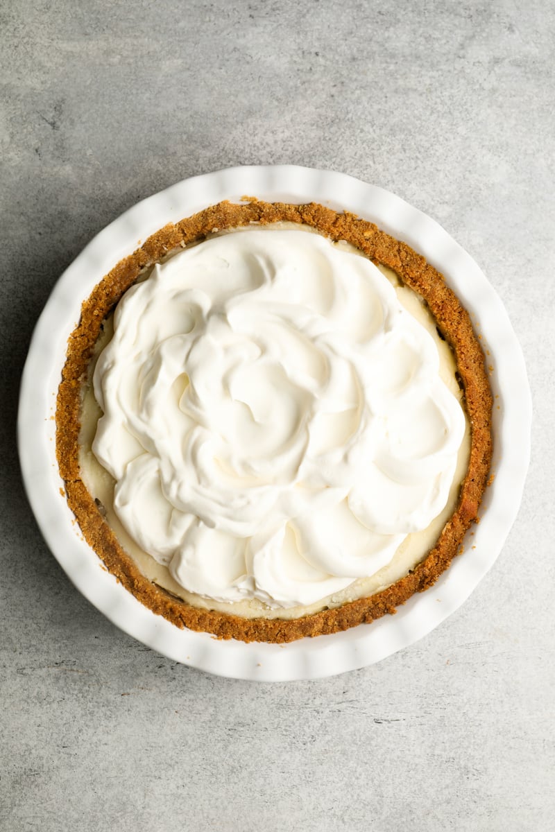 banana cream pie topped with decoratively swirled whipped cream