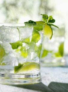Mojito in a glass with ice, limes, and mint.