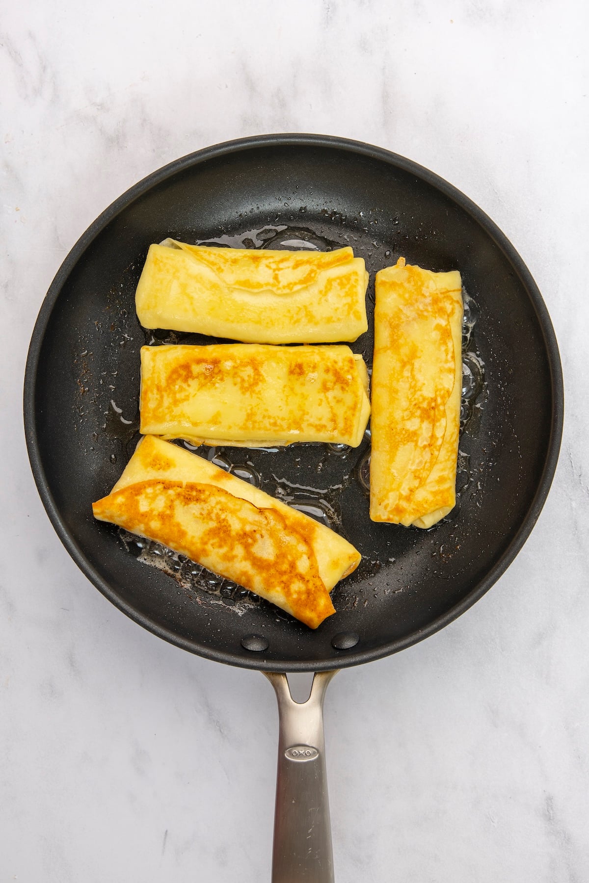 cooking one side of assembled blintzes in 10-inch nonstick skillet