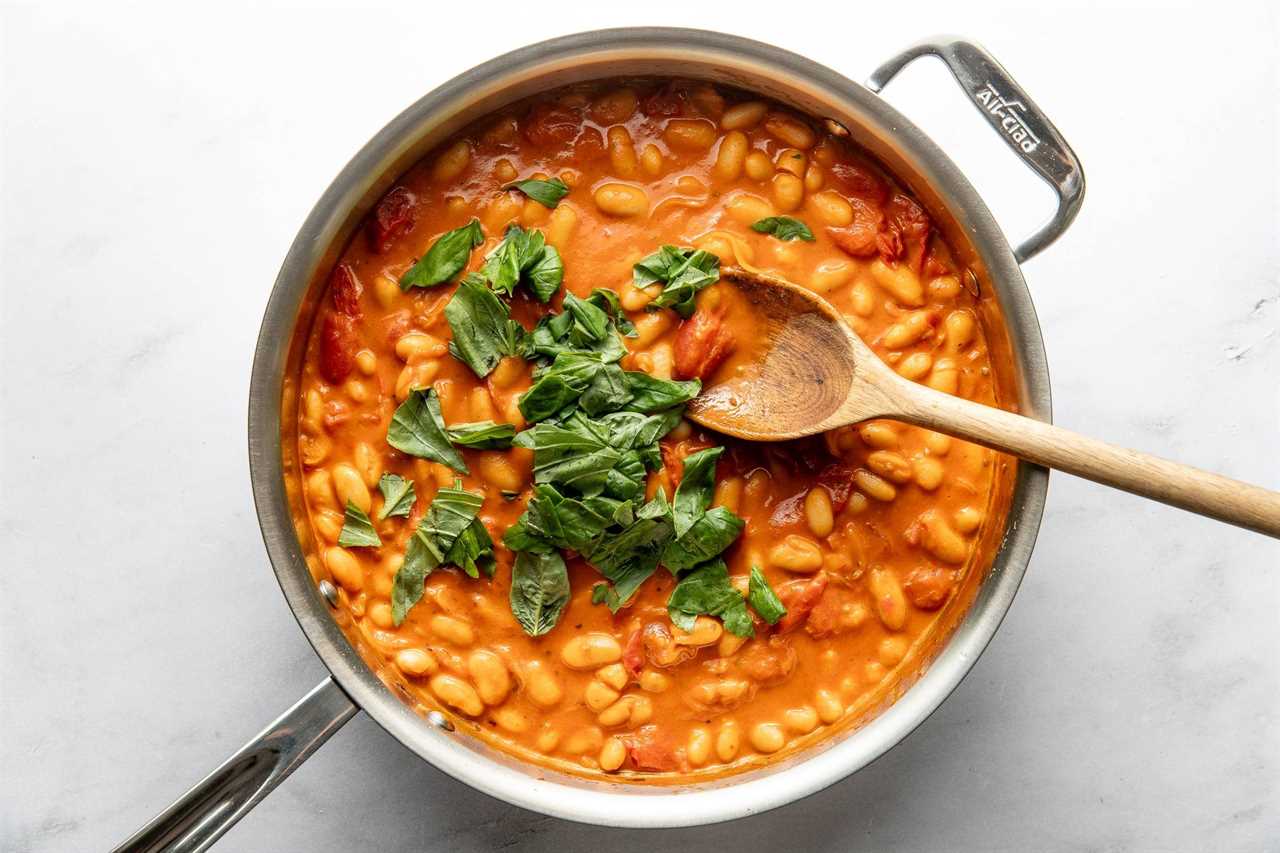 Creamy beans in a pan with basil.