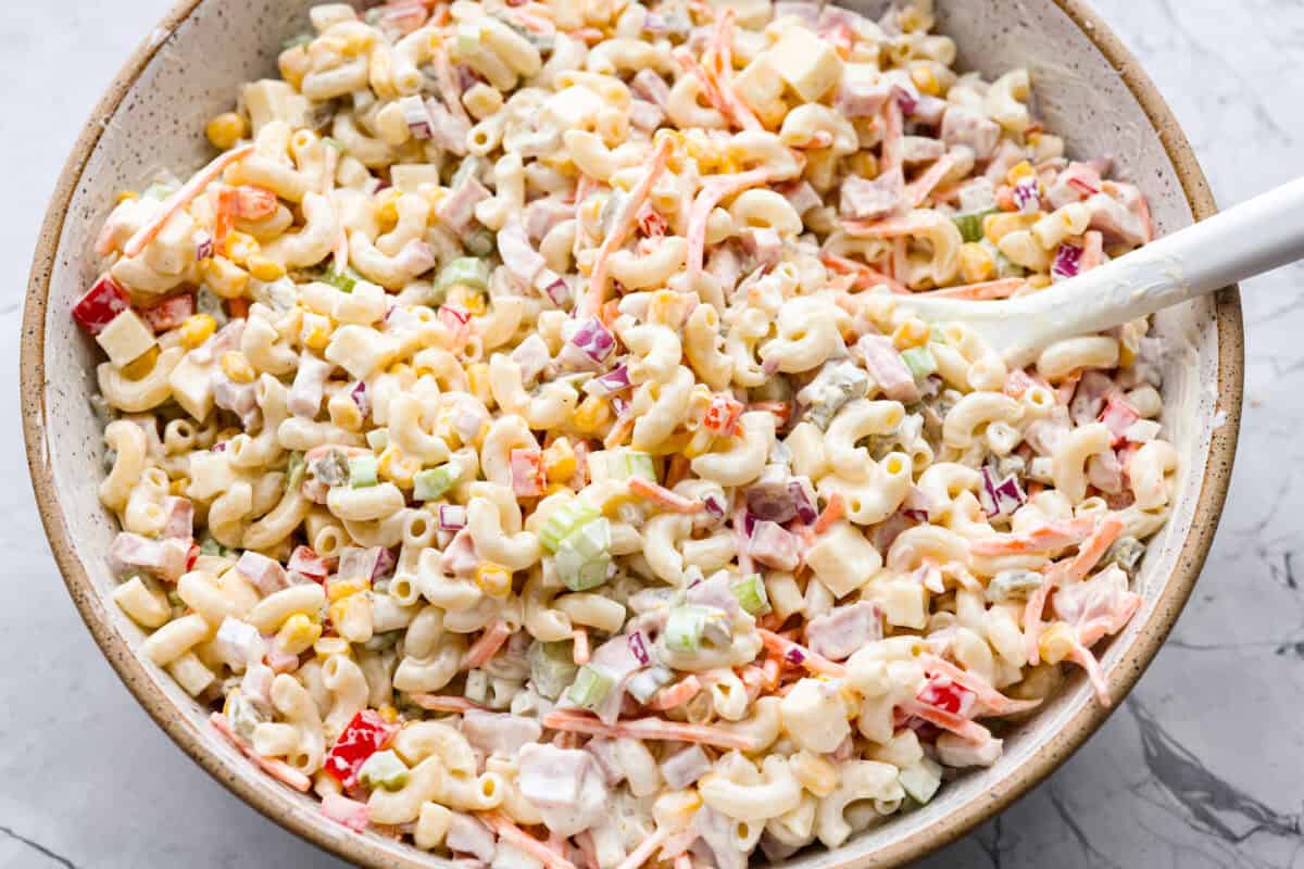 Mexican macaroni salad ingredients all mixed together with the dressing. 