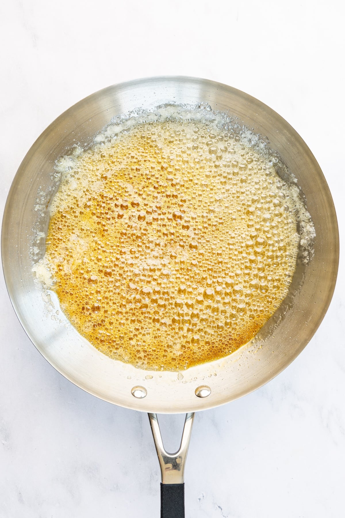 12-inch skillet with boiling sugar and water mixture