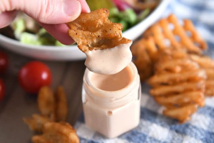 Dipping sweet potato waffle fry in creamy sauce.