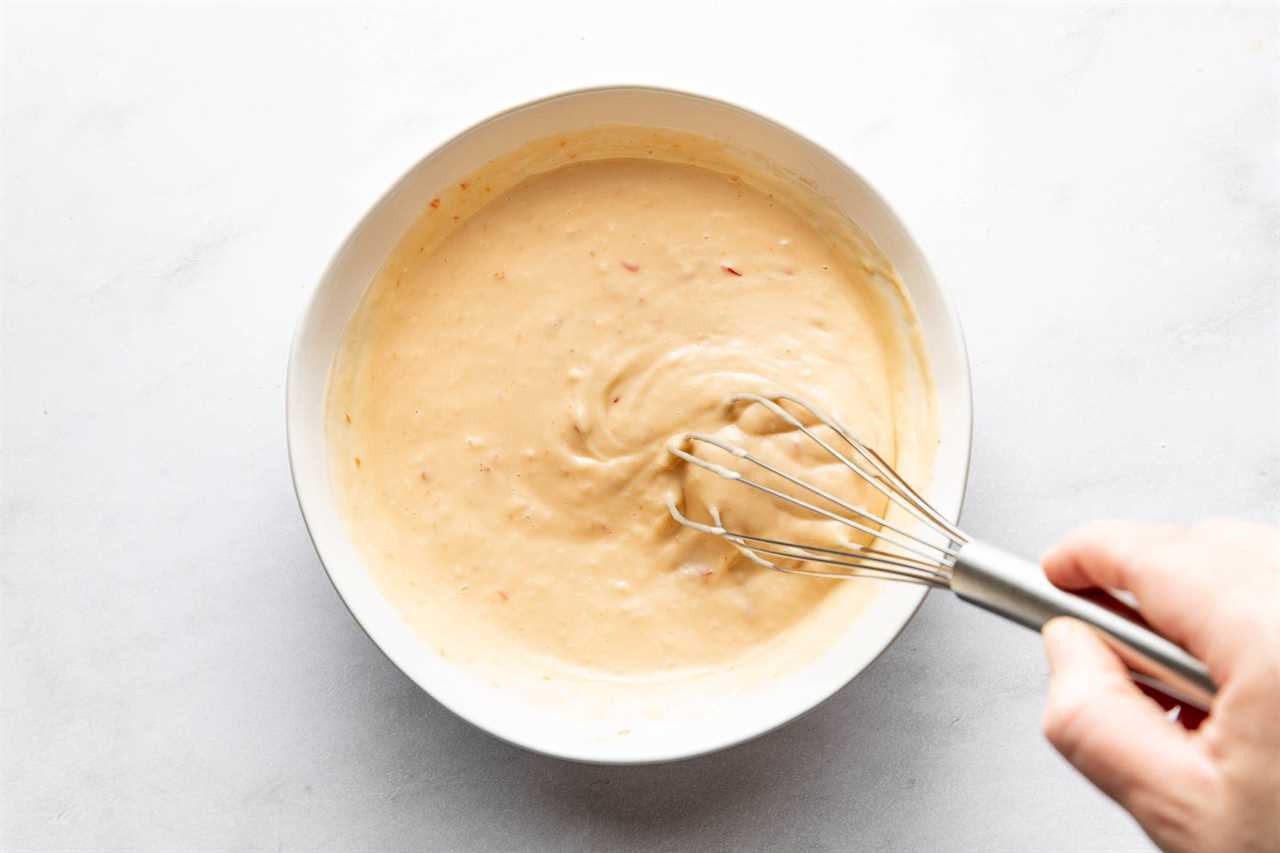 Whisking bang bang sauce in a bowl.