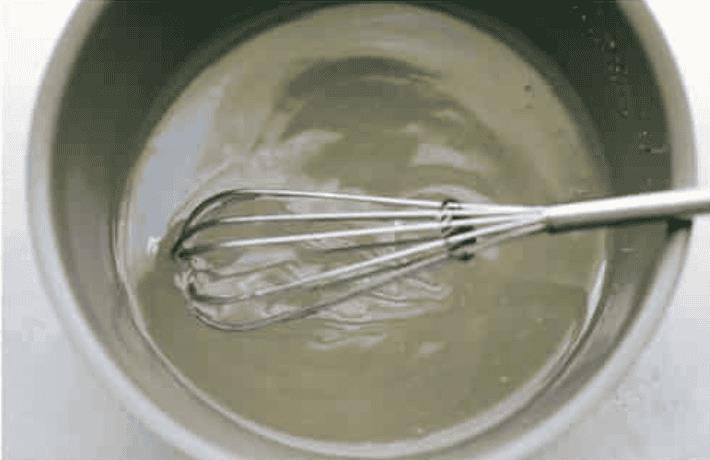 Whisking water, sugar, and cornstarch to create a glaze. 