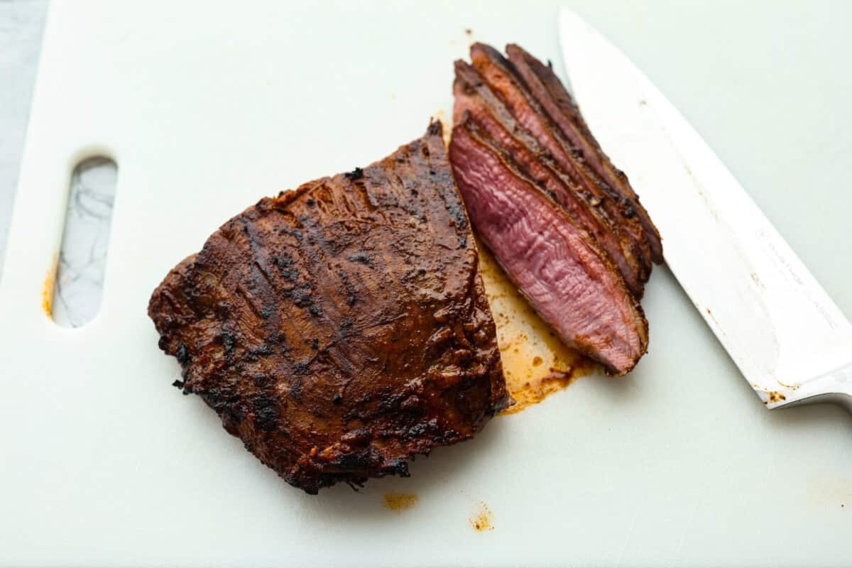 Someone slicing the cooked steak. 