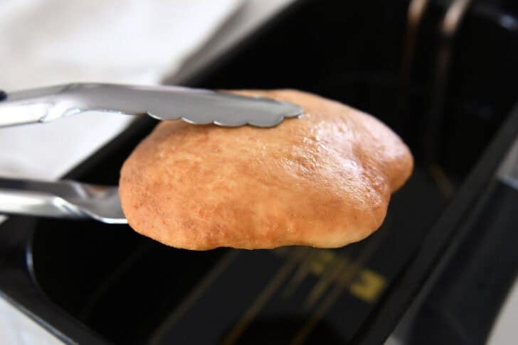 Piece of fry bread dough in electric oil fryer.