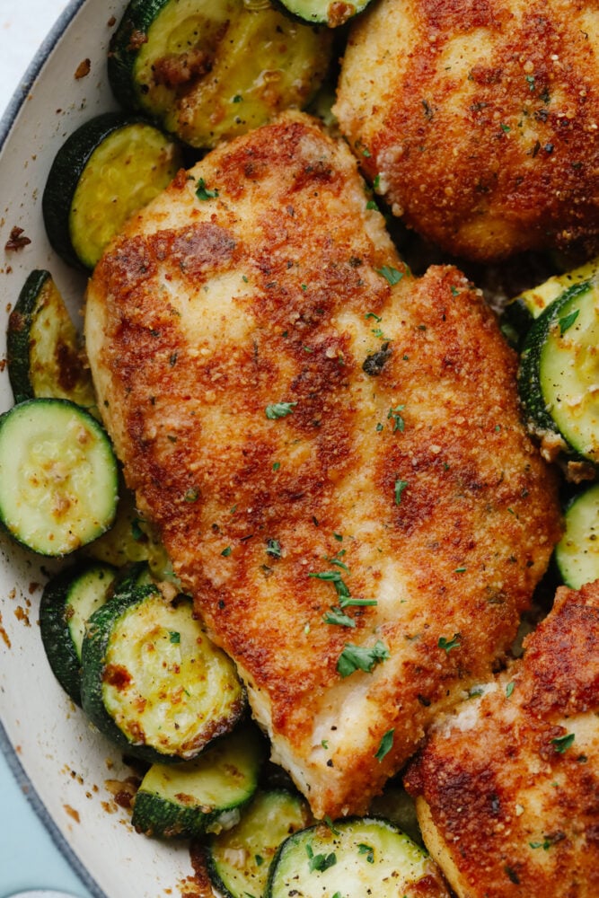 Close-up of crispy parmesan garlic chicken with zucchini.