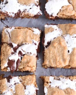Top down view of golden brown s'mores cookie bars with fissures of gooey marshmallow and melted chocolate throughout each bar.