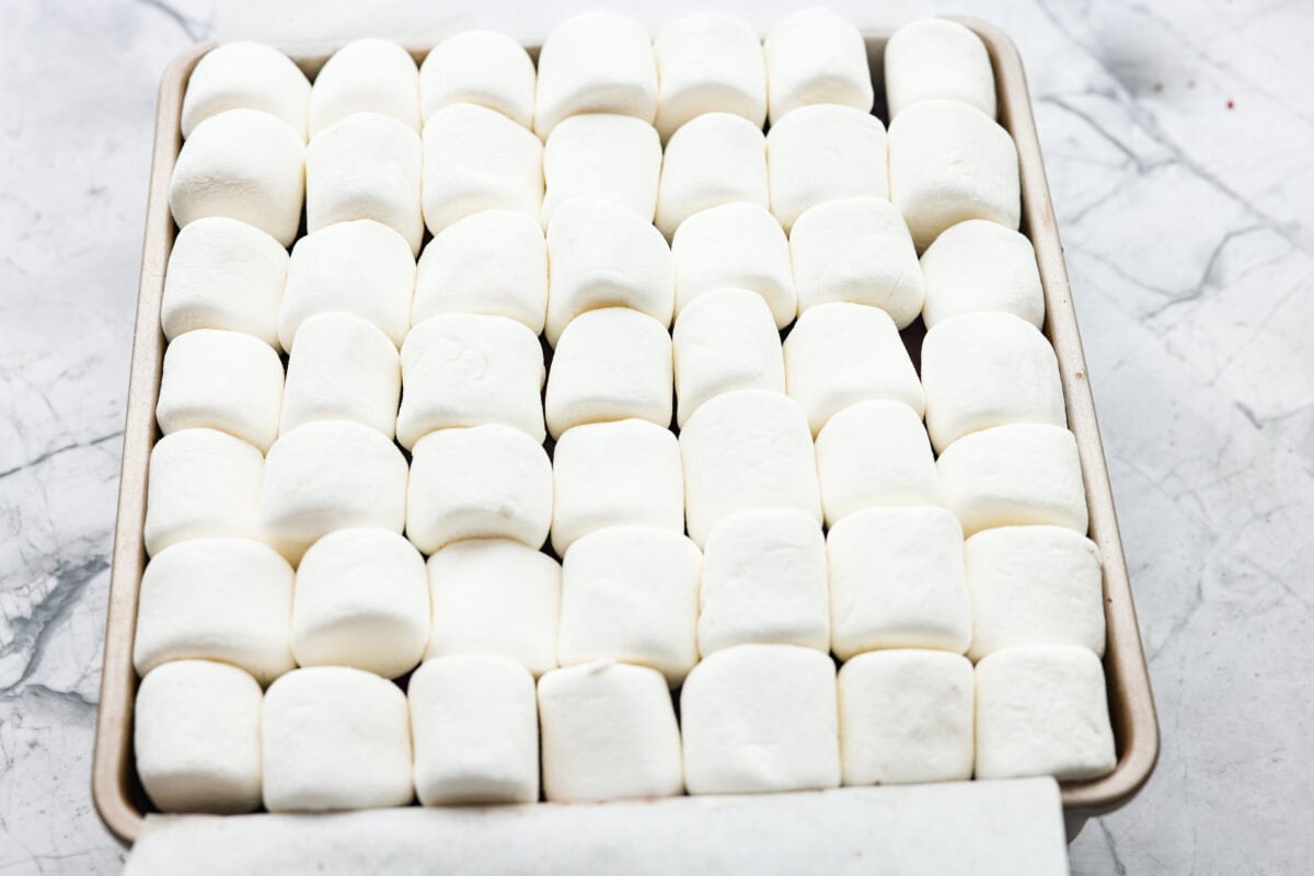 Marshmallows spread on top of the brownie mixture.