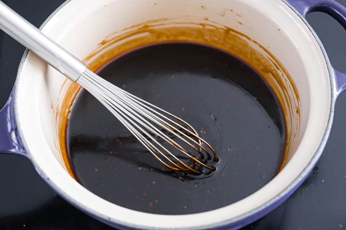 Someone whisking the thickened teriyaki sauce.