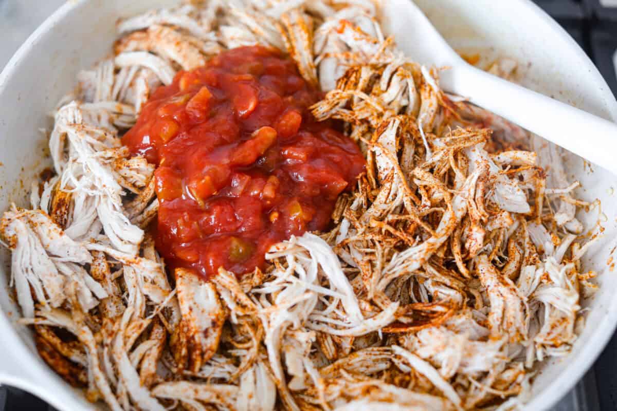 Salsa, lime juice, and chicken broth added to the chicken in the skillet.