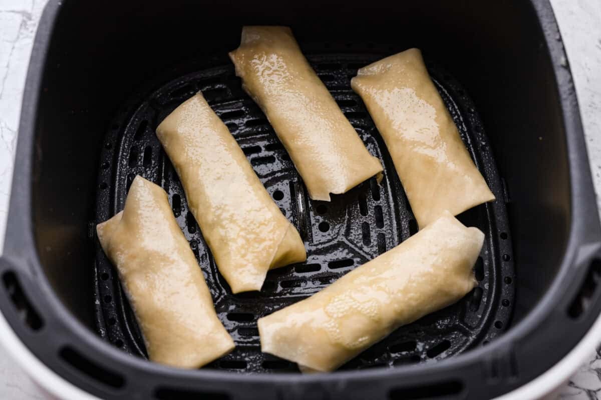 Egg rolls placed in the bottom of the air fryer and sprayed with oil. 