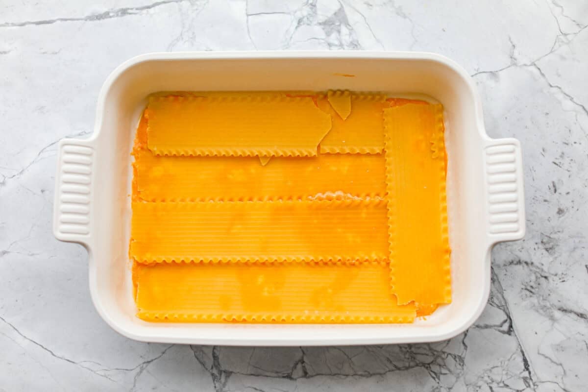 Oven ready lasagna noodles spread out over the buffalo sauce mixture. 