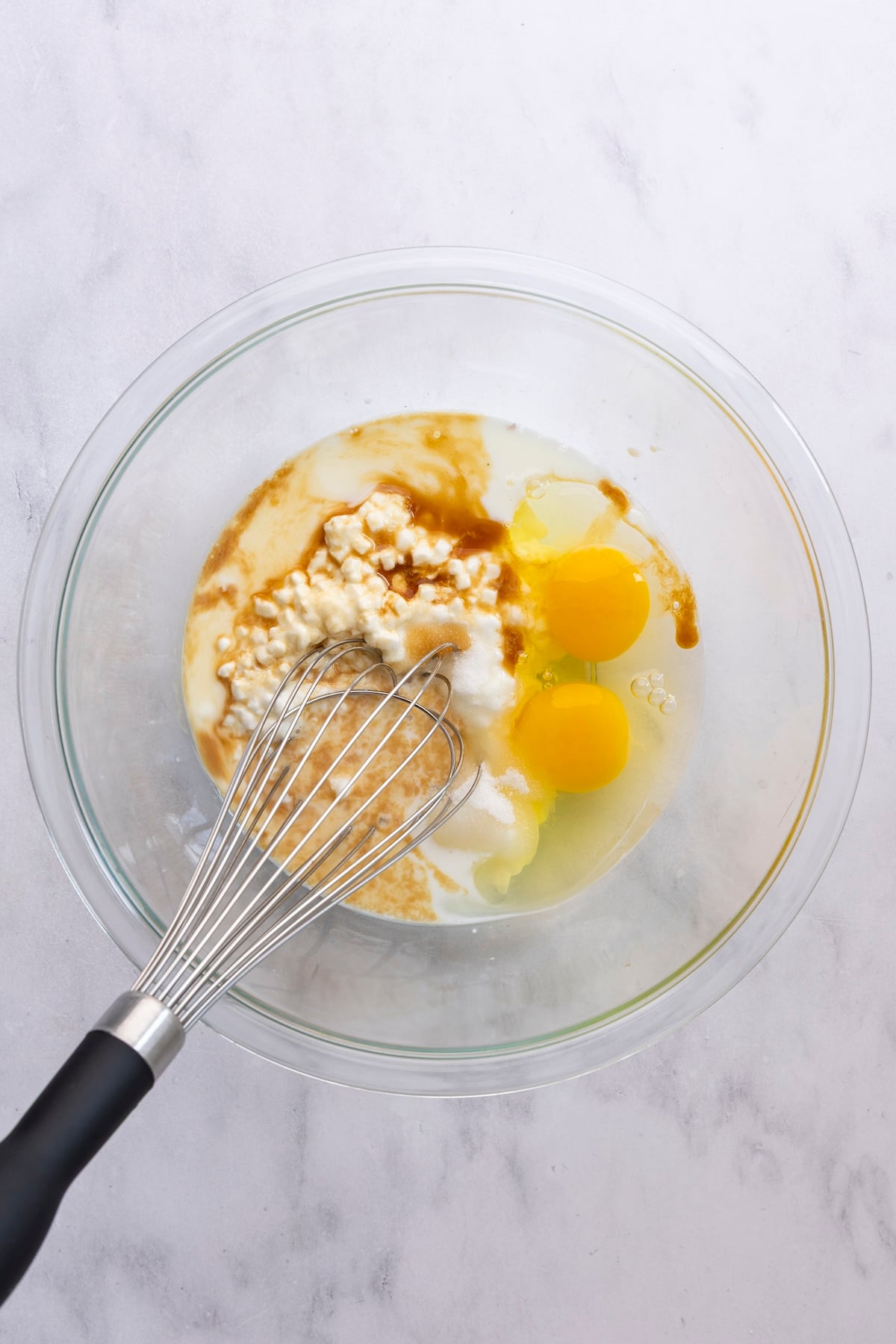 medium bowl with cottage cheese, milk, eggs, sugar, and vanilla added