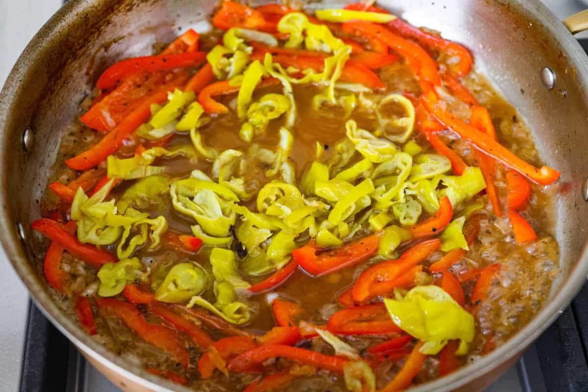 Pepperoncini's cooking in a skillet with the peppers and chicken broth. 