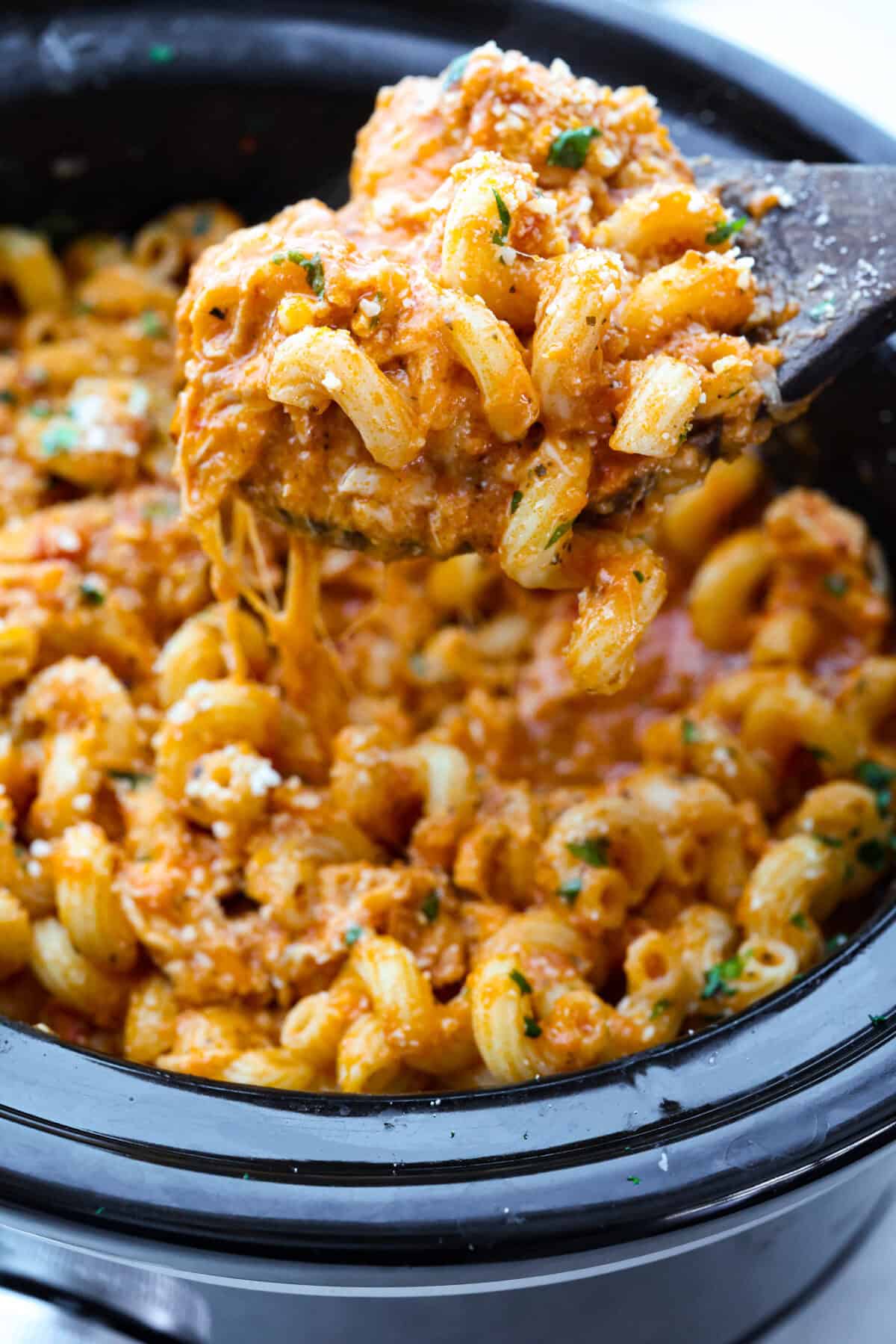 Close up shot of a scoop of crockpot creamy chicken pasta. 