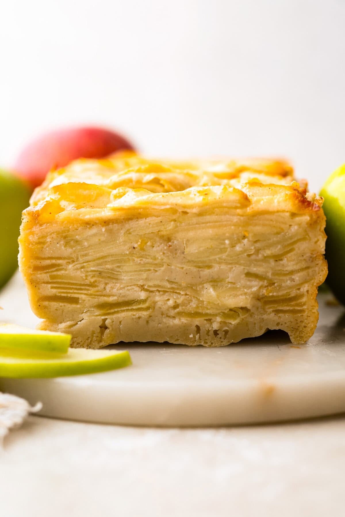Side side of a slice through invisible apple cake. 