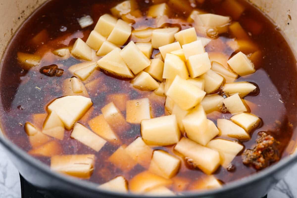 Beef broth and diced potatoes added to the pot. 