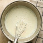 Bechamel sauce in pot with whisk.