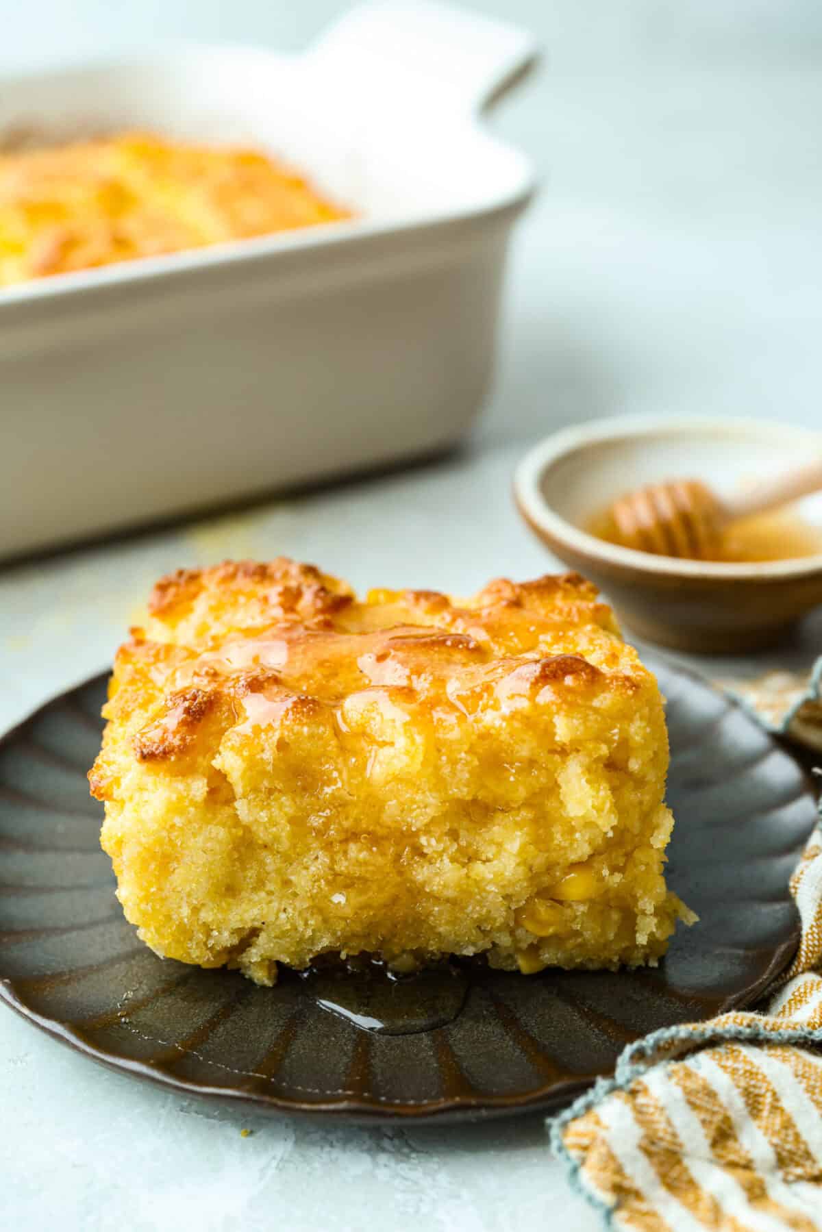 Slice of butter swim cornbread with a drizzle of honey.