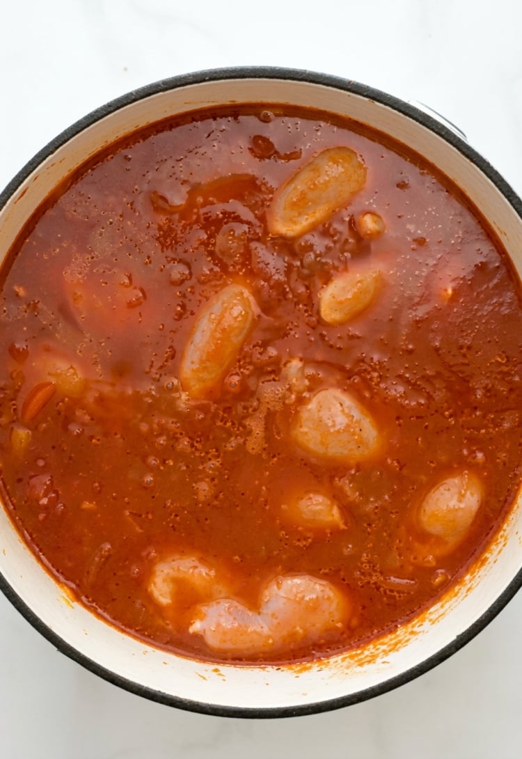 Chicken cooking in pot of chicken paprikash. 