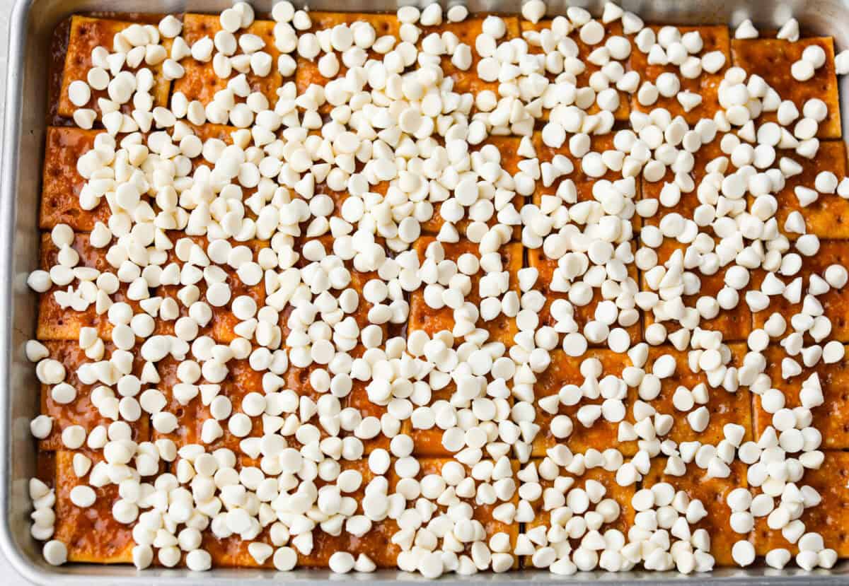 White chocolate chip wafers sprinkled over the top of the toffee and crackers. 