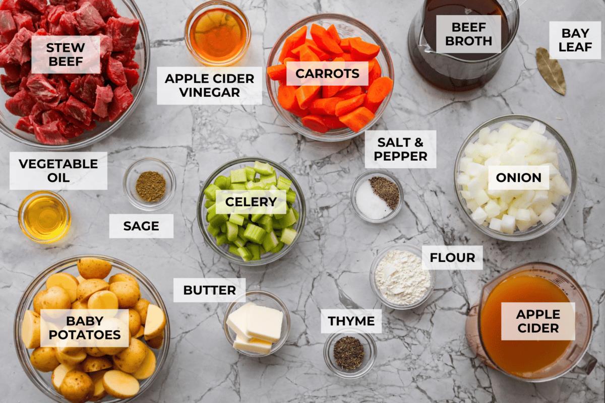 Overhead shot of labeled apple cider beef stew ingredients.