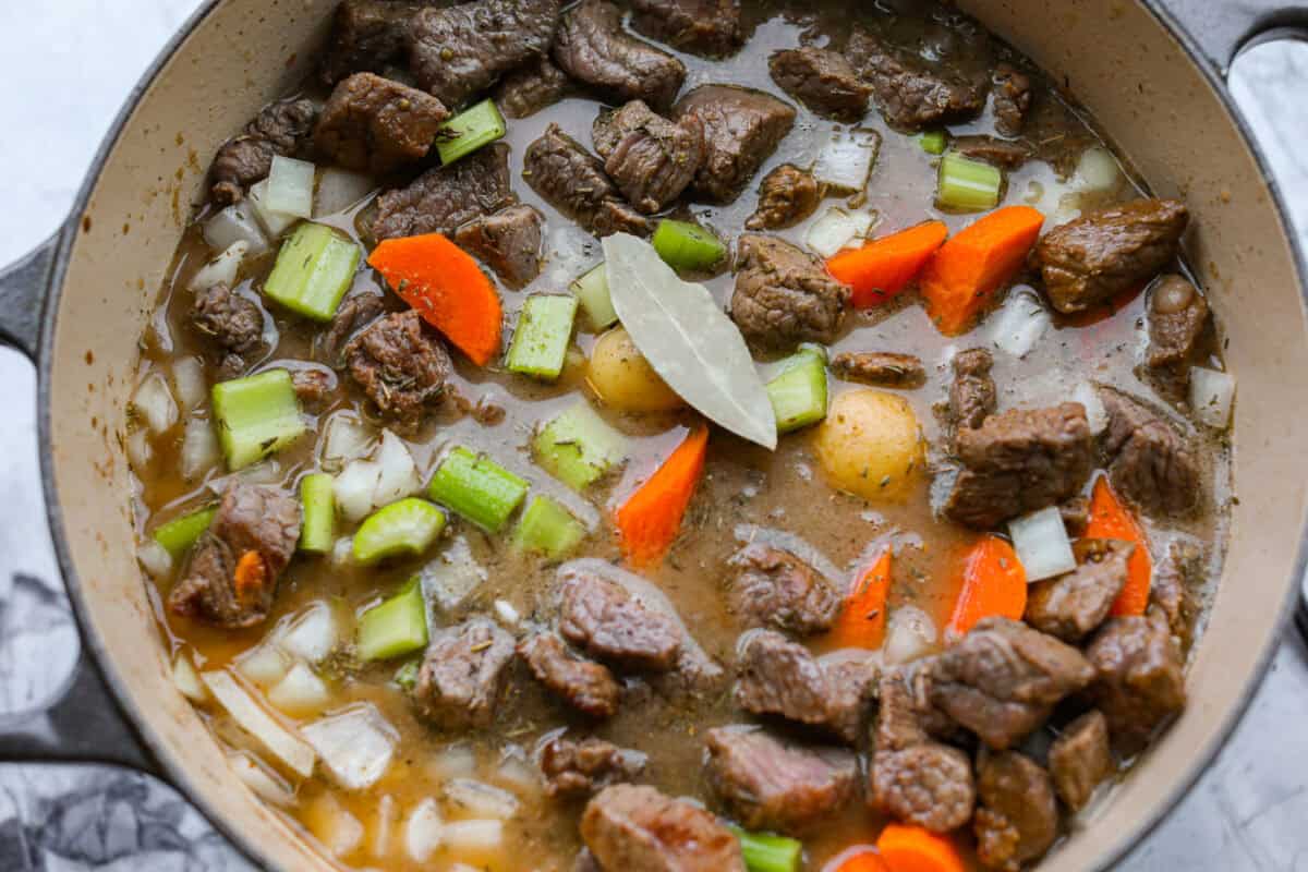 Stew ingredients added to a large pot to simmer and cook. 