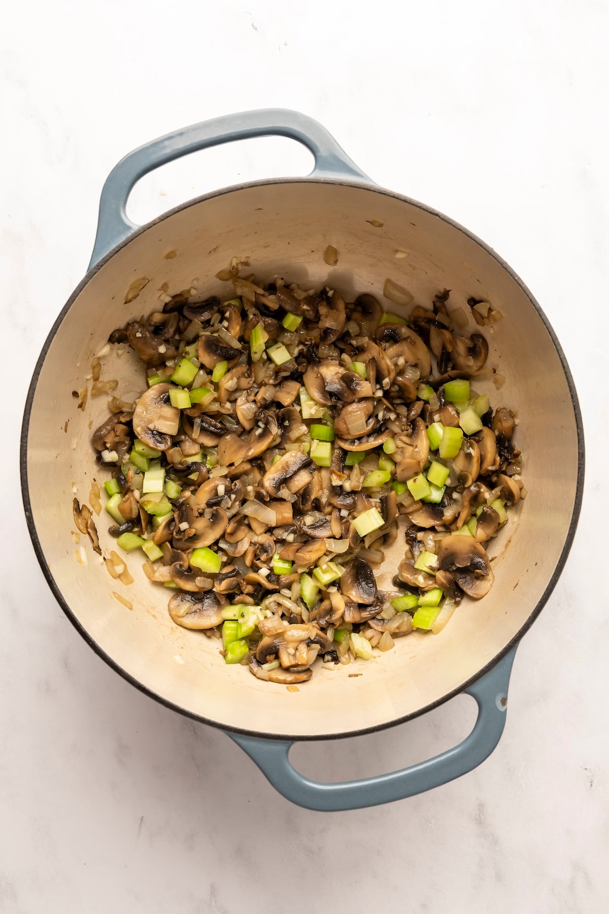 dutch oven with garlic and celery added to onion/mushroom mixture