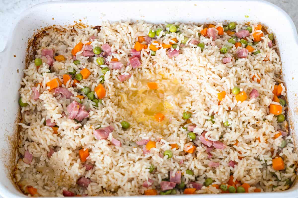 Eggs poured into the middle of the well made into the rice mixture. 