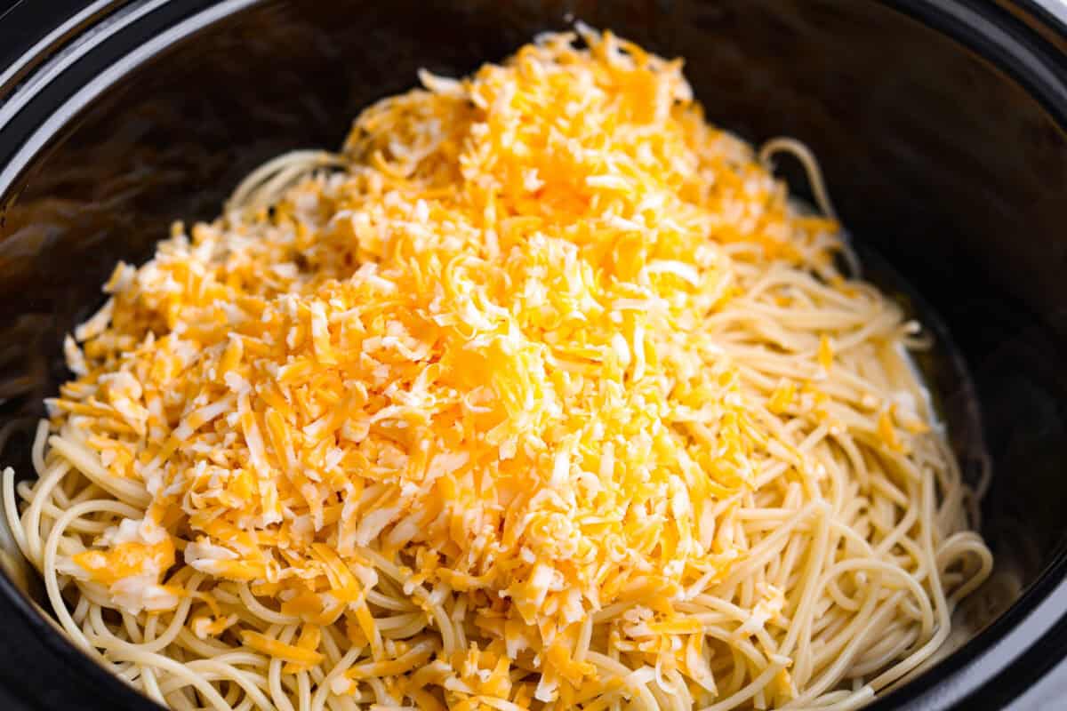 Cooked pasta and cheese added to the slow cooker. 