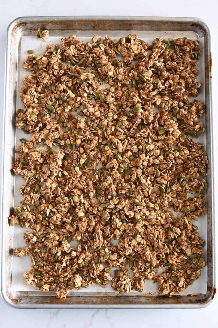 Sheet pan covered with unbaked pumpkin pecan granola.