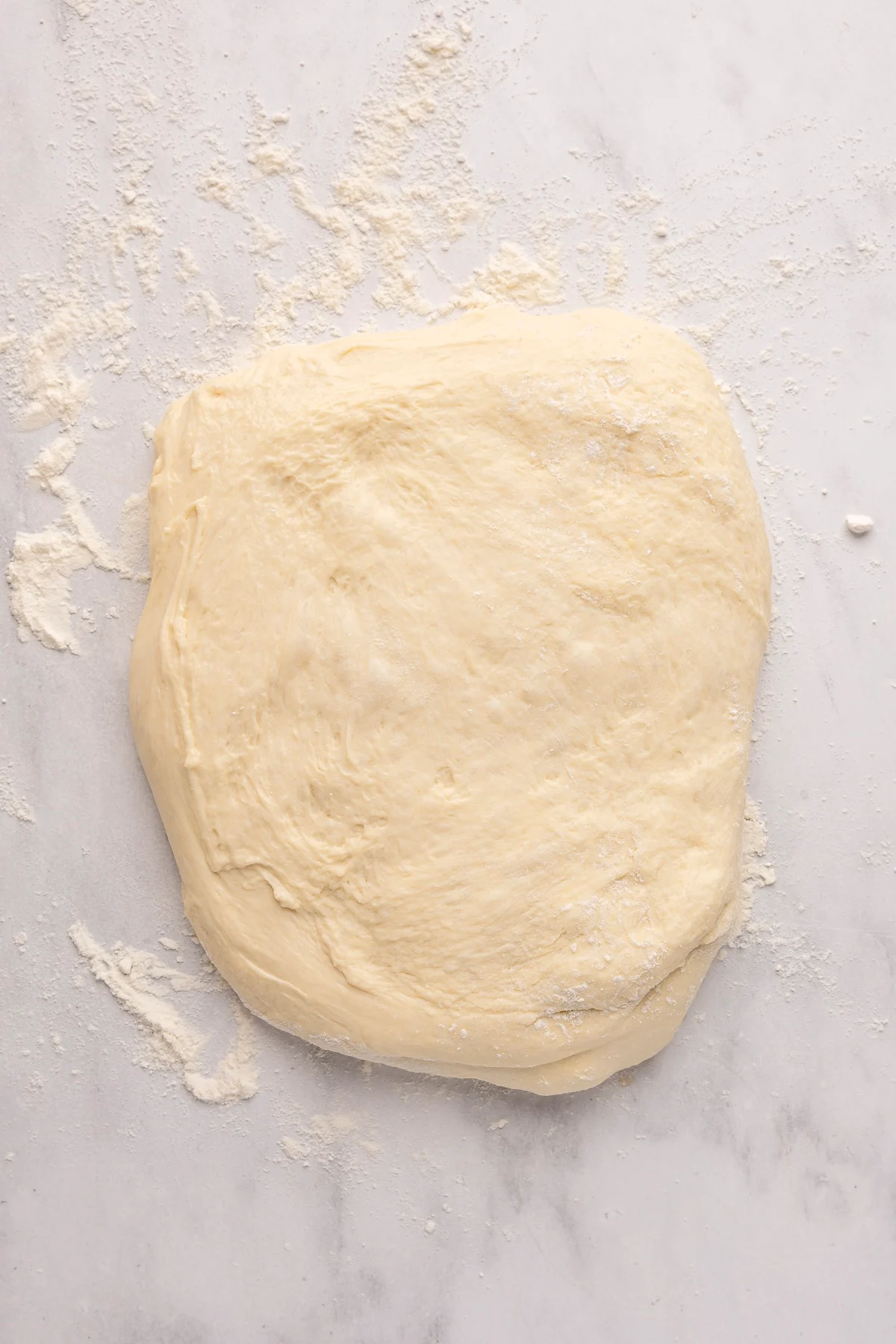 english muffin dough in rectagular shape on flour dusted surface